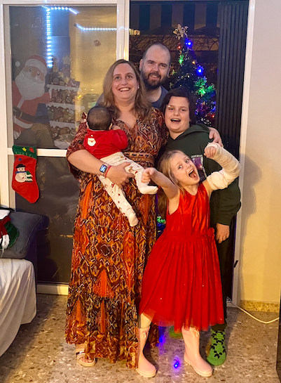 Foto de familia posando en navidad con nuestro tercer bebé de aocgida en brazos