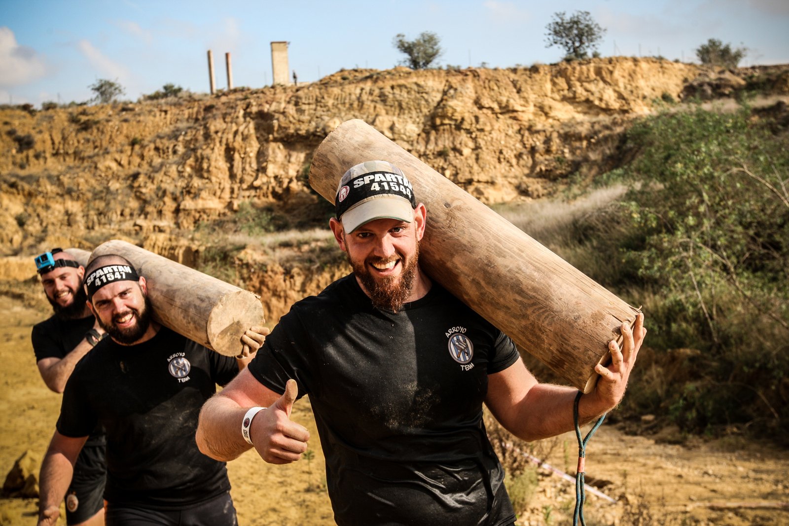 Foto con mis hermanos llevando un tronco al hombro en la Spartan Race