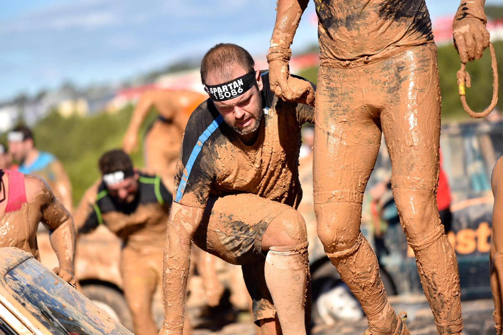 Foto superando un obstáculo alto con la ayuda de Joaquin mi guia en mi primera Spartan Race