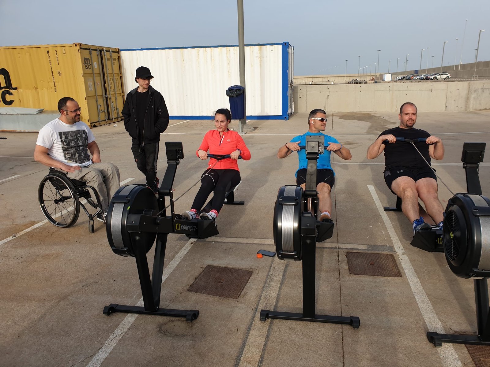 Foto remando en el ergo con David y Celia en el puerto, junto al contenedor del club